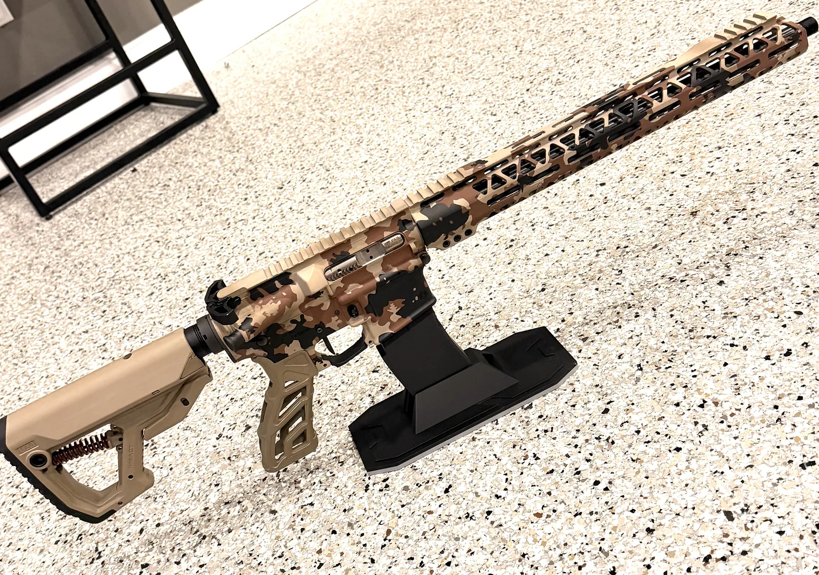Desert camo AR build on a display stand